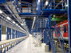 Vista de la escalera en dos tramos, de conexión al altillo de acceso a la plataforma de trabajo, con panel de mandos en puente de control.